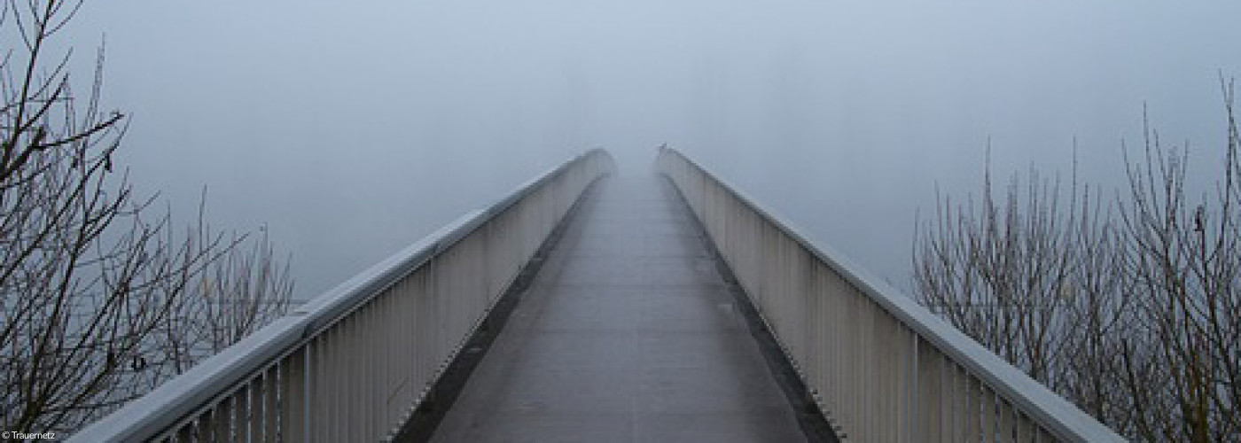 Eine Brücke führt in den Nebel