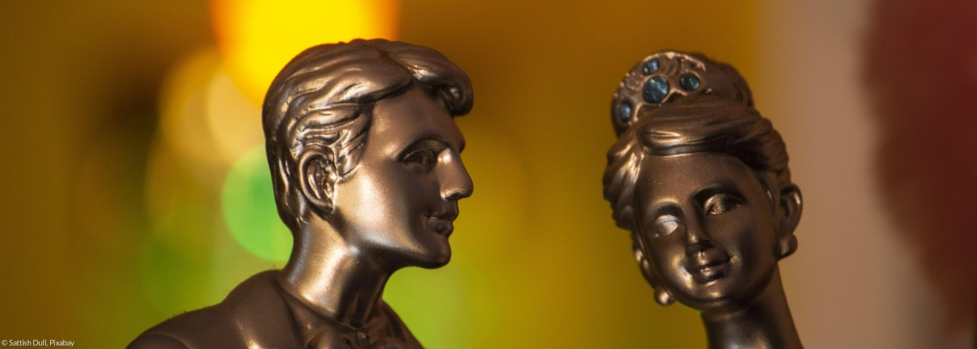 Ein Mann flüstert einer Frau etwas zu