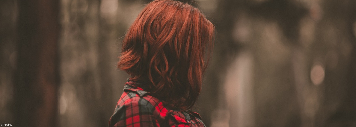 Der Kopf einer Frau vor einem dunklen Hintergrund
