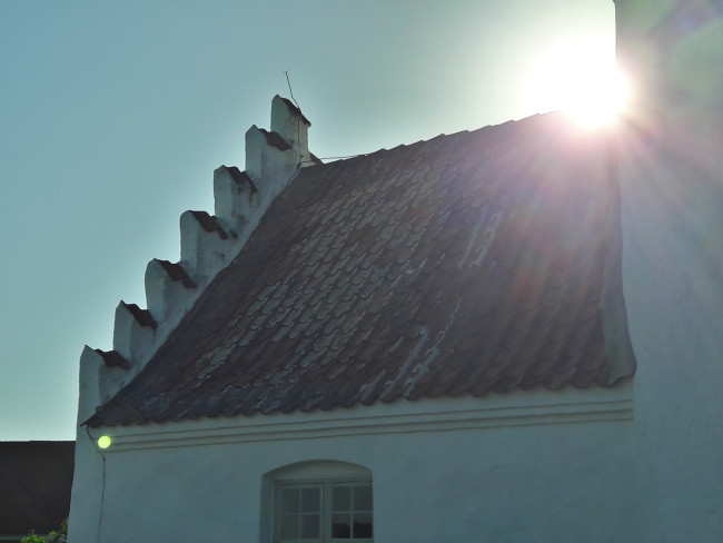 Die Abendsonne scheint über ein Kirchendach